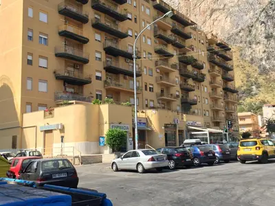 a parking lot with cars parked in front of a building at casavacanzabordonaro in Palermo