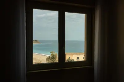a window with a view of a beach at casavacanzabordonaro in Palermo