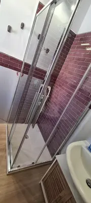 a bathroom with a glass shower and a sink at Ruby Home in Palermo