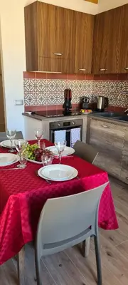a table with a red table cloth on it with wine glasses at Ruby Home in Palermo