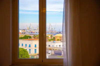 an open window with a view of a city at Solemar Sicilia - Vista Mare Alla Cala in Palermo