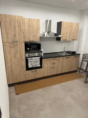 a kitchen with wooden cabinets and a stove top oven at Casa Leo in Palermo