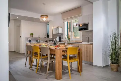 a kitchen with a wooden table and yellow chairs at Villa Coraline - Castellammare in Balata di Baida