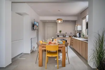 a kitchen with a wooden table and yellow chairs at Villa Coraline - Castellammare in Balata di Baida