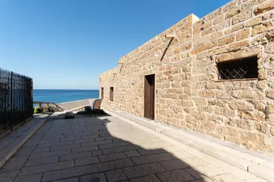 a brick wall with a door and the ocean in the background at Villa Napunta in Terrasini