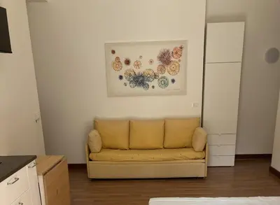 a living room with a couch and a painting on the wall at Sunny studio with terrace in best central area in Palermo