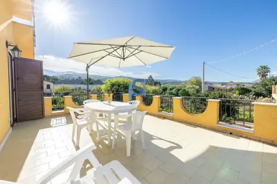 a patio with a table and chairs and an umbrella at Villa Oltremare in Lascari