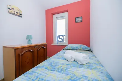 a bedroom with a bed with two towels on it at Villa Oltremare in Lascari