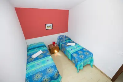 a room with two beds and a red wall at Villa Oltremare in Lascari
