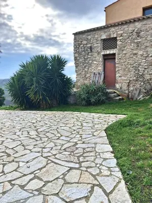 a stone path in front of a building with a red door at Agriturismo Masseria Castellana in Monreale