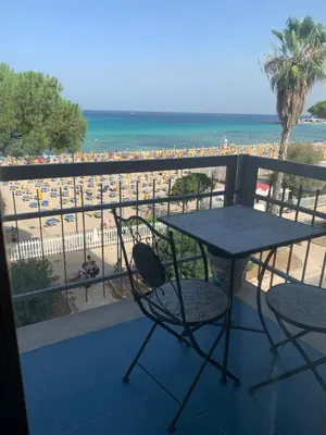 a balcony with a table and chairs and a beach at Rocca Appartament Palermo Beach in Palermo