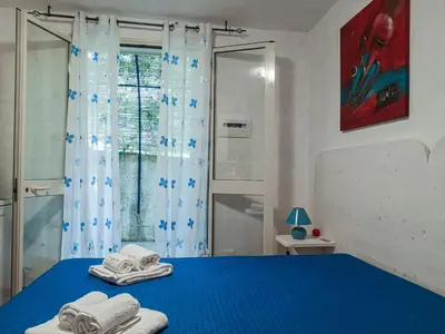 a bedroom with a blue bed with towels on it at Casaulente Mare in Alcamo Marina