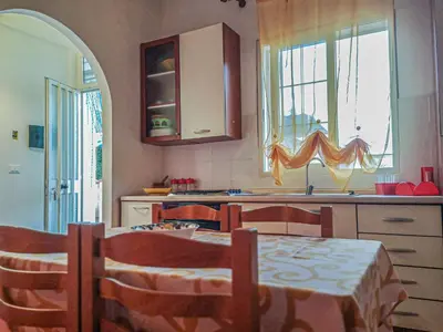 a kitchen with a table and chairs and a kitchen with a table and a table at Casaulente Mare in Alcamo Marina