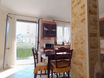a dining room with a table and chairs and a window at Casa La Plaza in Balestrate