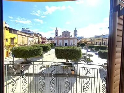 a balcony with a view of a building in a city at Casa La Plaza in Balestrate