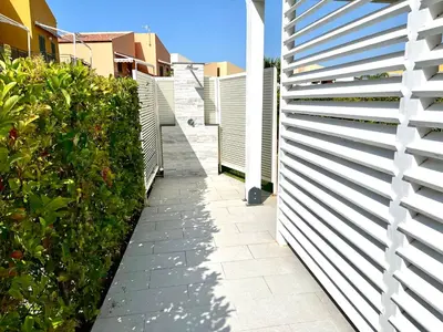 a white fence next to a walkway at Casa Roccella in Buonfornello