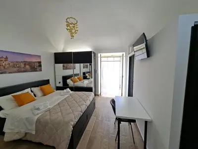 a bedroom with a bed and a desk in it at Central Post Office Guest House in Palermo