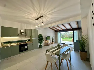 a kitchen with green cabinets and a table and chairs at Casa Manzella Apartments in Cinisi