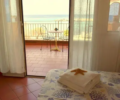 a bedroom with a bed and a view of the ocean at Mare Holidays in Palermo