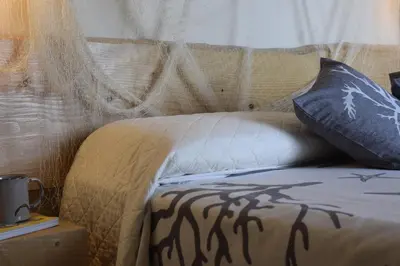 a bed with a pillow with a shadow on it at Mare Holidays in Palermo