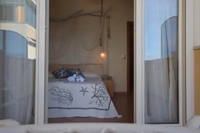 a bedroom with a bed through a glass door at Mare Holidays in Palermo