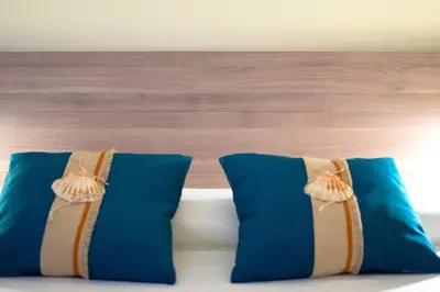 two blue pillows sitting on top of a bed at Mare Holidays in Palermo