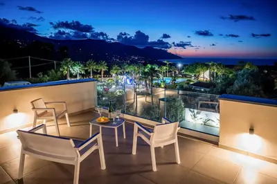 a balcony with chairs and a table and a view at Rosvì Villa in Castellammare del Golfo