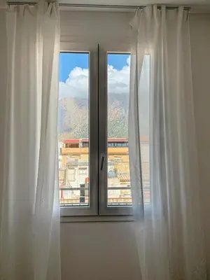 a window with white curtains and a view at Casa Lo Bianco in Terrasini
