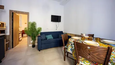 a living room with a table and a blue couch at Living Ballarò by Rentbeat in Palermo