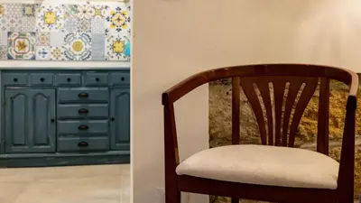 a wooden chair sitting next to a kitchen at Living Ballarò by Rentbeat in Palermo