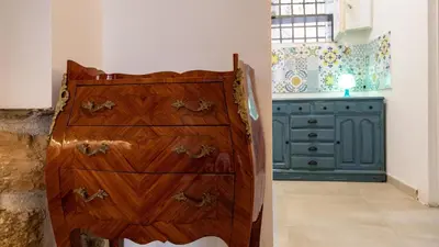 a wooden dresser in a kitchen with a green cabinet at Living Ballarò by Rentbeat in Palermo