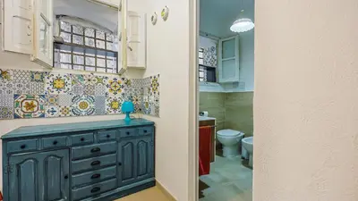 a bathroom with a blue cabinet and a toilet at Living Ballarò by Rentbeat in Palermo