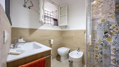 a bathroom with a sink and a toilet and a window at Living Ballarò by Rentbeat in Palermo