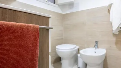a bathroom with a toilet and a sink at Living Ballarò by Rentbeat in Palermo