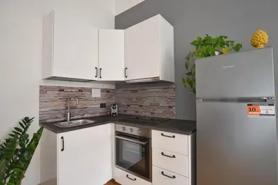 a kitchen with white cabinets and a refrigerator at La Lumia Apartment in Palermo