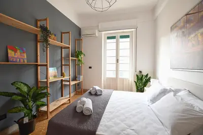 a bedroom with a bed with slippers on it at La Lumia Apartment in Palermo