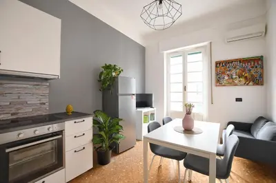 a kitchen with a table and a living room at La Lumia Apartment in Palermo