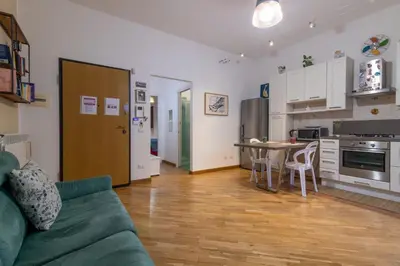 a living room with a green couch and a kitchen at GuestHost - Al Cassaro Holiday Home in Palermo