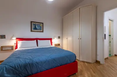 a bedroom with a red bed and a white cabinet at GuestHost - Al Cassaro Holiday Home in Palermo