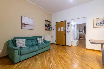 a living room with a green couch and wooden floors at GuestHost - Al Cassaro Holiday Home in Palermo
