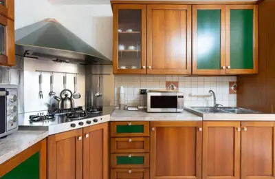 a kitchen with wooden cabinets and a sink and a microwave at Villa Oasi della Pace based in Partinico in Partinico