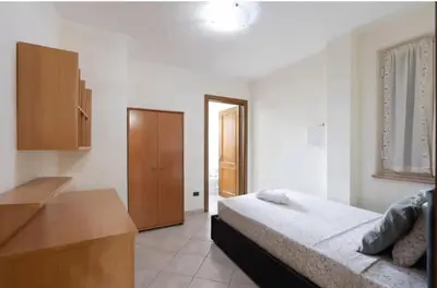 a bedroom with a bed and a wooden cabinet at Villa Oasi della Pace based in Partinico in Partinico