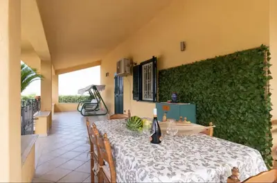 a dining room with a table and a green wall at Villa Oasi della Pace based in Partinico in Partinico