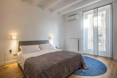 a bedroom with a large bed and a large window at Mori apartment Libertà Politeama in Palermo