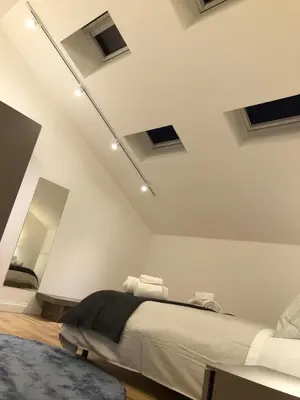 a white room with a bed and a mirror at Mori apartment Libertà Politeama in Palermo