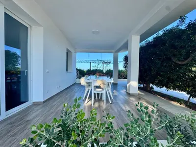 a dining room with a table and large windows at Al Grande Pino - Private pool, Jacuzzi and amazing Sunset in Campofelice di Roccella