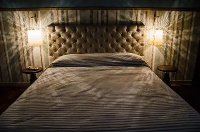 a bed in a bedroom with two lamps on both sides at Guelio al Massimo Suites&Breakfast in Palermo
