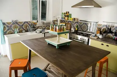 a kitchen with a wooden table with orange chairs at Guelio al Massimo Suites&Breakfast in Palermo