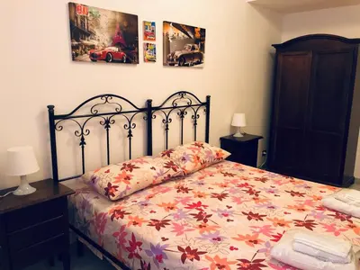 a bedroom with a bed with a floral bedspread at Attico Giusy in Balestrate