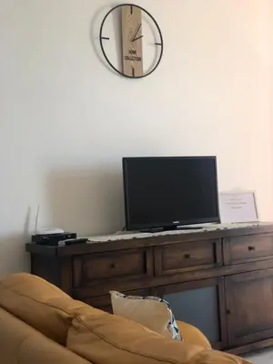a television sitting on a wooden desk with a couch at Attico Giusy in Balestrate